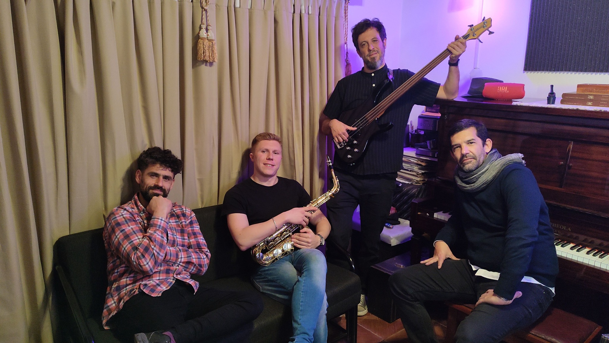 Los cuatro músicos de EchoSonic Studios juntos con sus instrumentos en el estudio